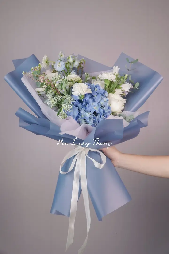 Bó hoa tươi gồm hoa hồng trắng, delphinium xanh, hoa baby, kiểu cắm lãng mạn