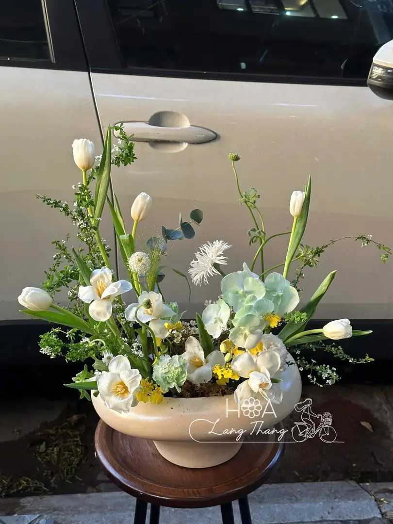 Bình hoa tươi với tulip, cúc, thủy tiên, kiểu cắm tự nhiên, màu trắng xanh
