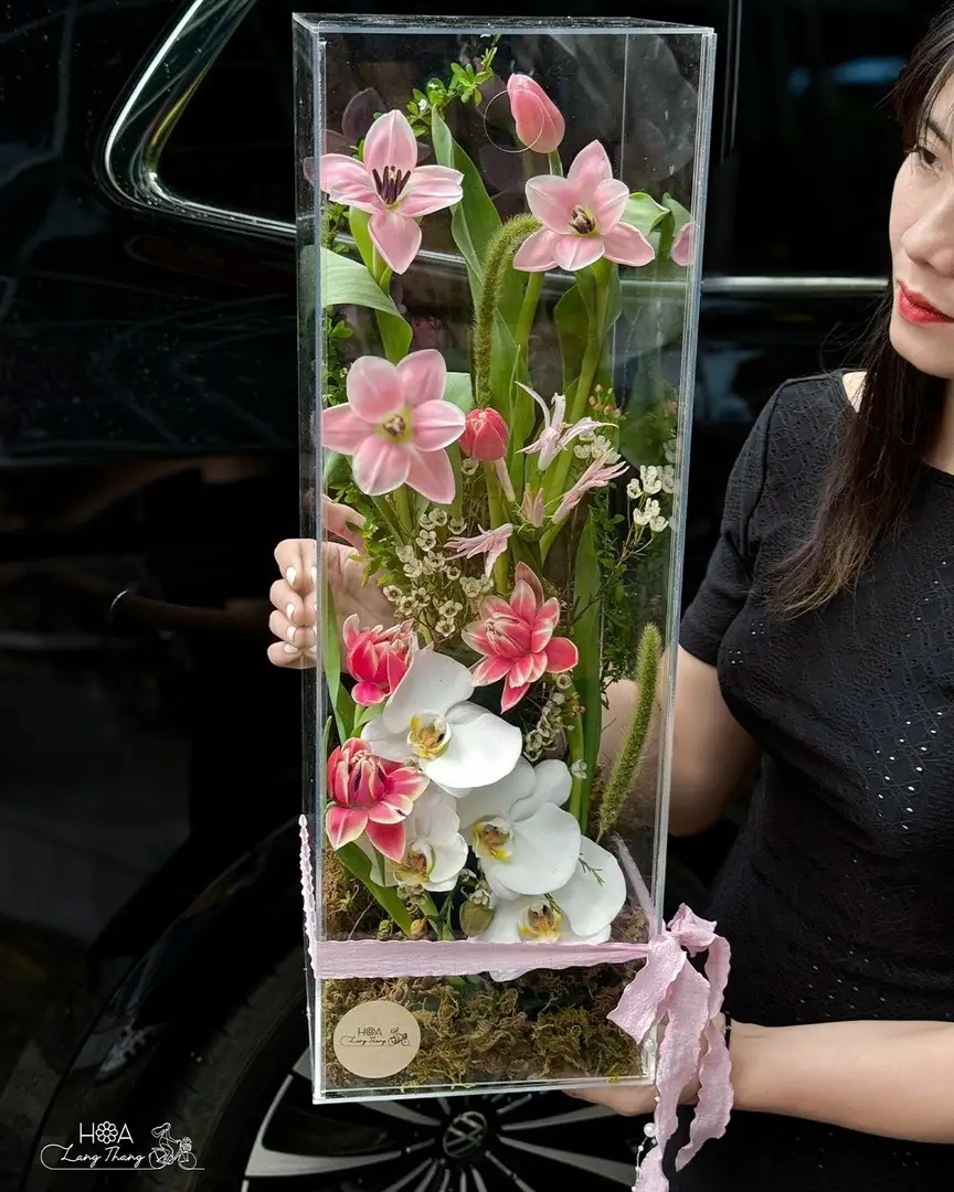 Bó hoa gồm hoa ly hồng và lan hồ điệp cắm trong hộp kính sang trọng