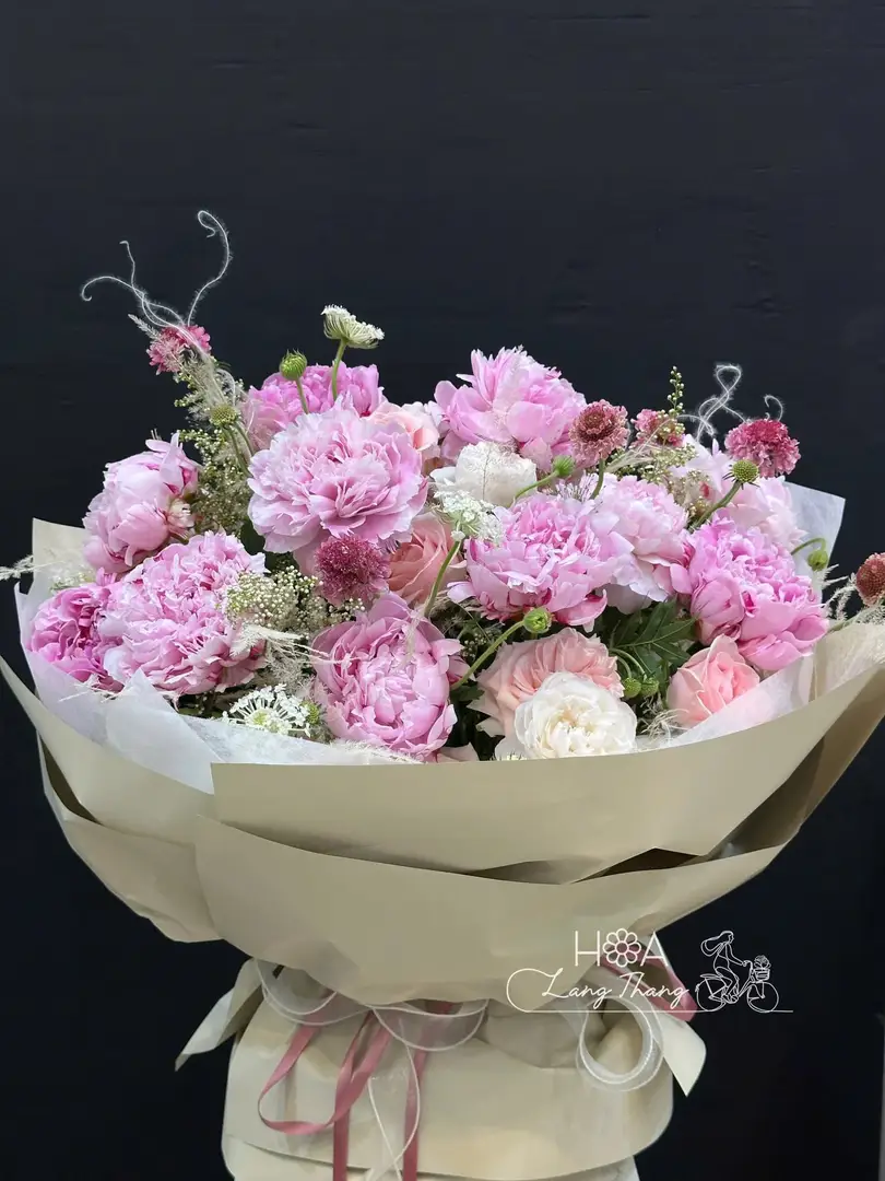 Bó hoa gồm nhiều loại hoa màu hồng tươi sáng, thích hợp cho dịp tặng. Kiểu cắm tự nhiên