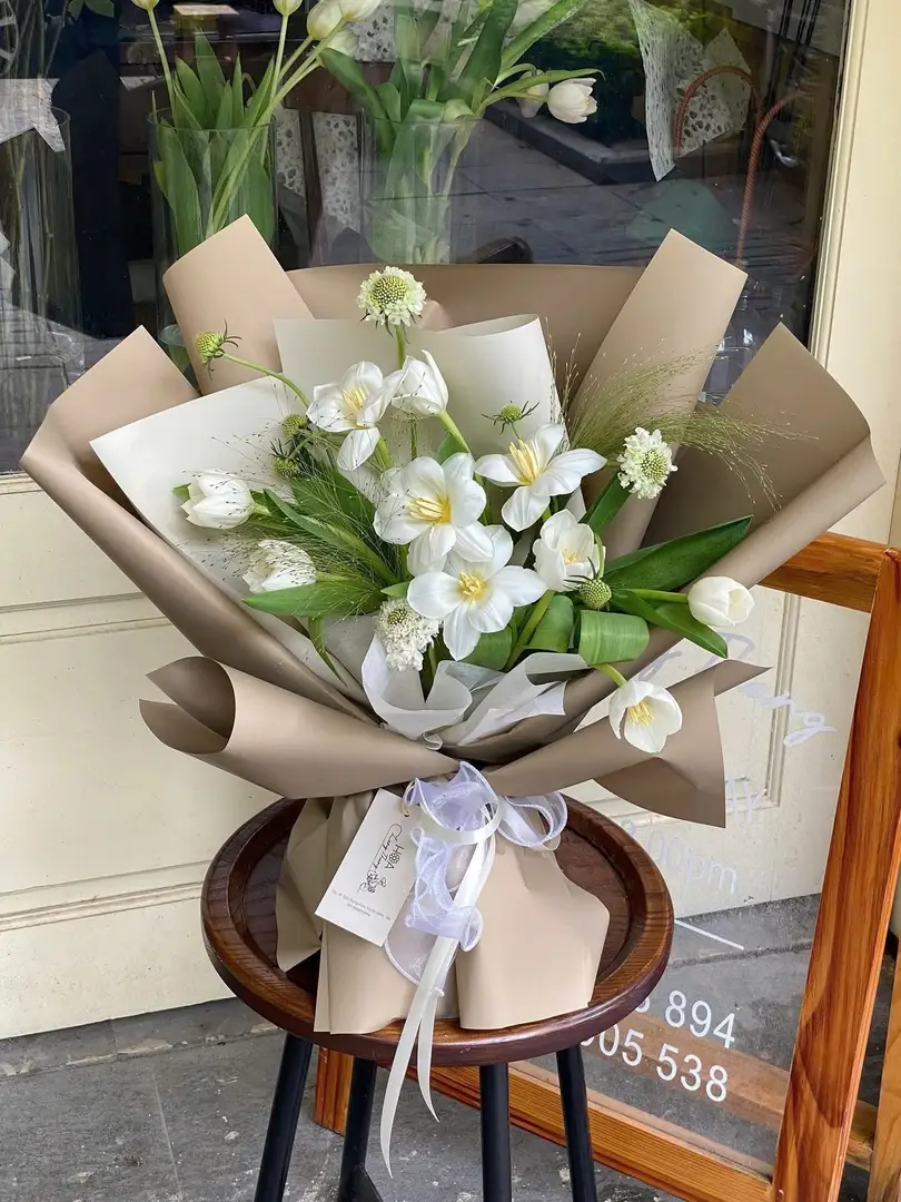 Bó hoa trắng tinh khôi gồm tulip, ly, và baby, kiểu cắm đẹp mắt